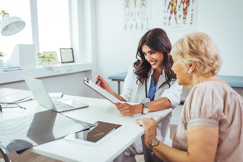 Female doctor explaining diagnosis to her patient. A smiling mid